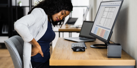 Office worker at desk experiencing back pain